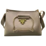 Beige handbag with metallic cat-shaped handle and gold accents front view